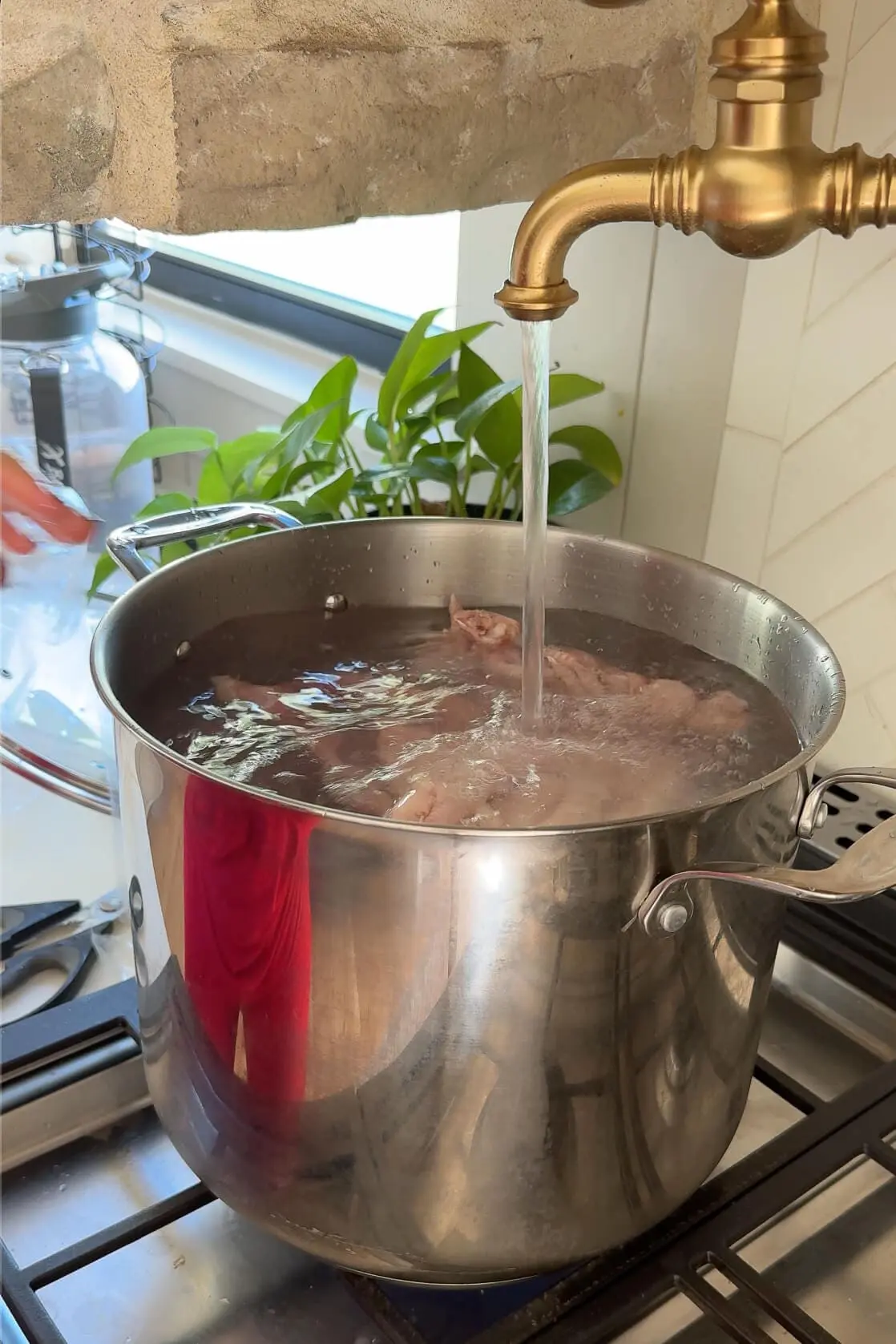 Skimming foam from the surface of simmering homemade chicken stock, ensuring a clear, rich, and flavorful broth made from scratch.